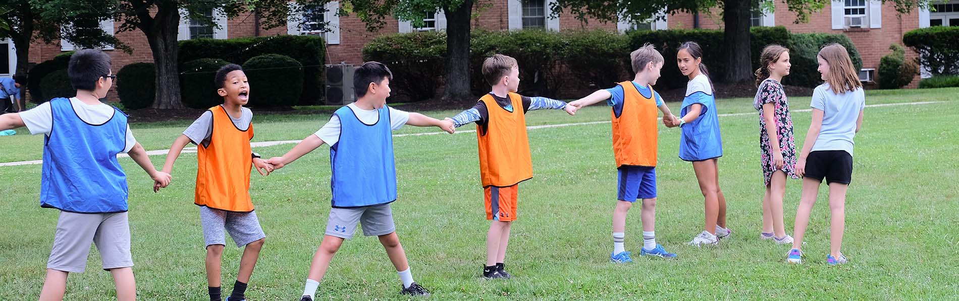 Eight 12 to 14 year olds lining up and holding hands for a game.