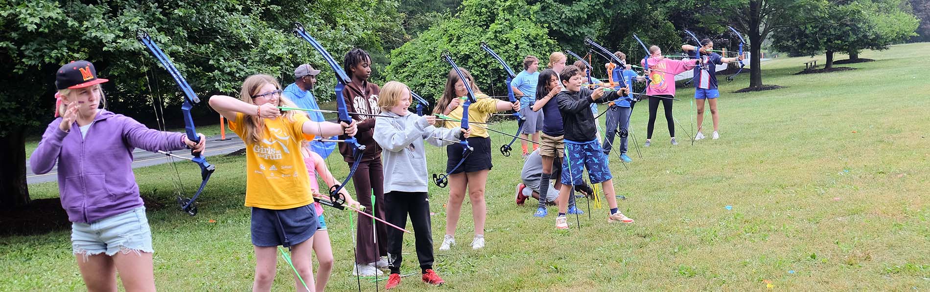 a group of youngsters shooting arrows in archery practice