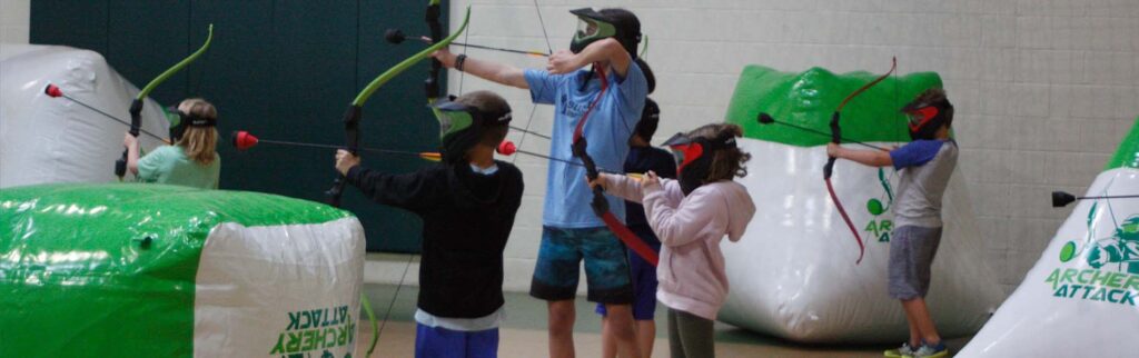 kids learning how to shoot the arrow in archery tag class