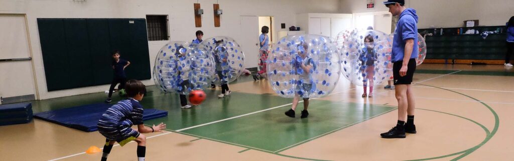 kids playing bubble soccer indoors