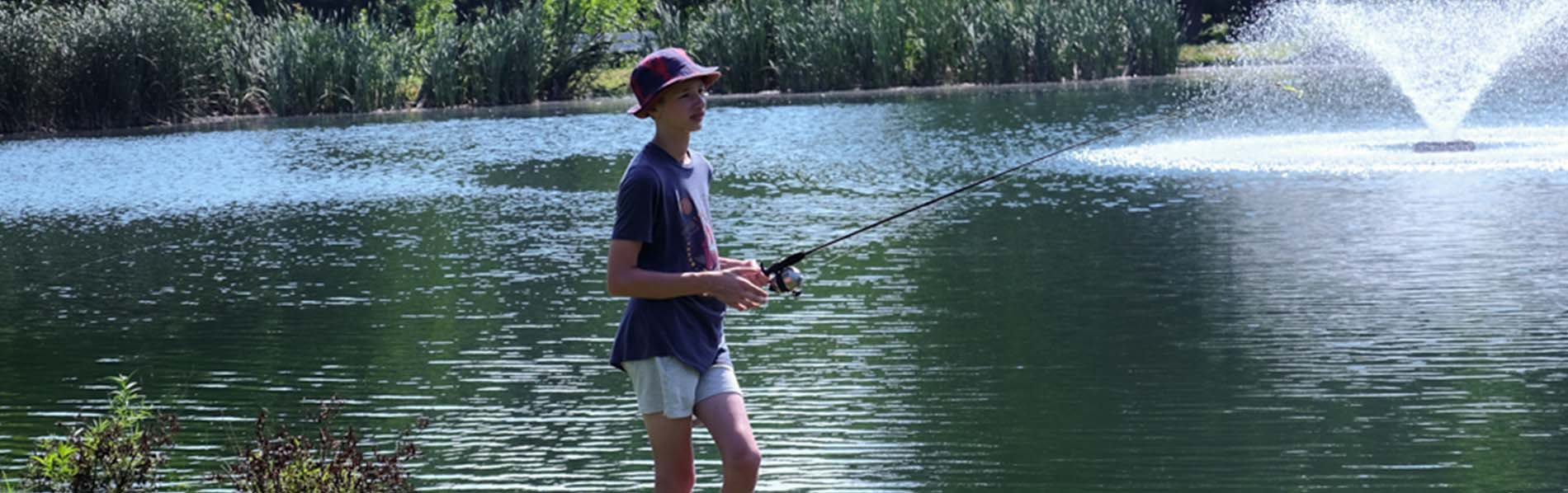 a young teen fishing on the pretty pond