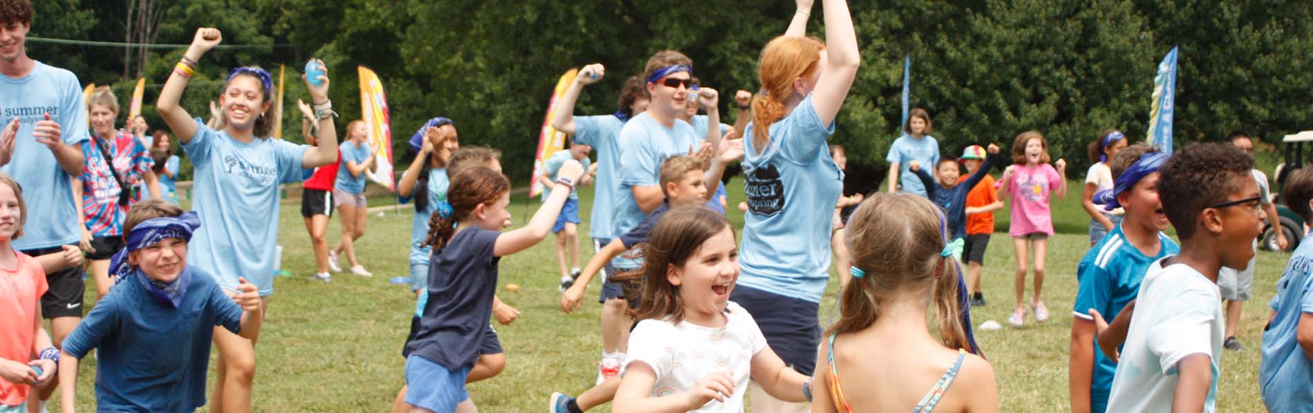 staff and kids cheering in a game outdoors